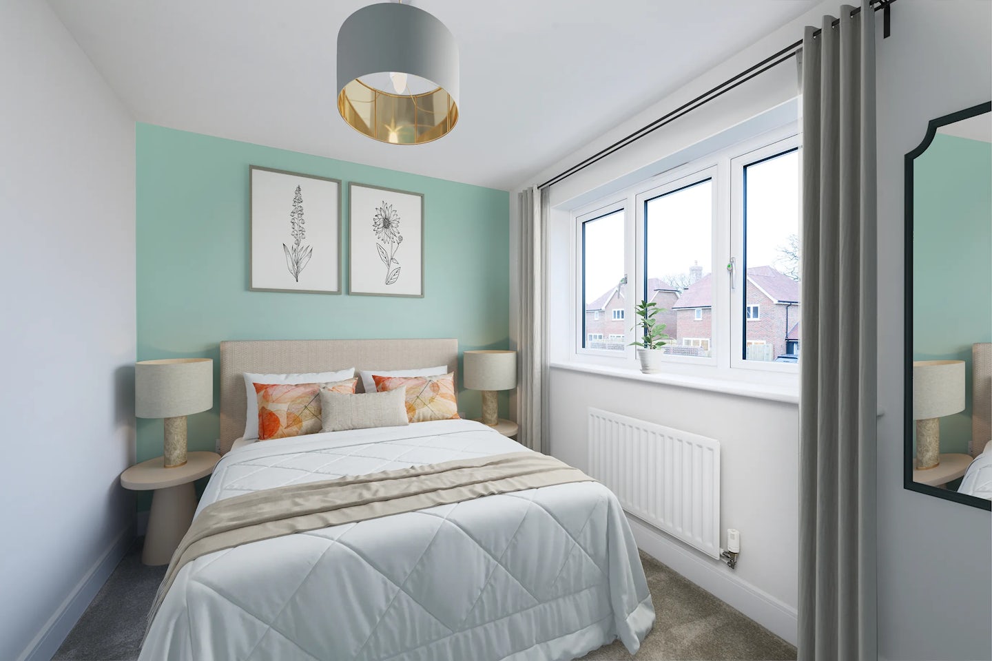 Stylish bedroom with a double bed featuring a padded beige headboard, dressed in crisp white bedding and accent pillows in burnt orange and beige patterns. Flanking the bed are two round bedside tables topped with textured lamps and small accessories. Above, two botanical prints hang on a mint green feature wall, adding fresh visual contrast. A large window with beige curtains and white framing lets in daylight, revealing red-brick houses and leafy trees outside. Below the window sits a white radiator, and a large mirror reflects part of the room to the right. A grey-and-gold pendant light hangs from the ceiling, illuminating the soft grey carpet and tranquil, coordinated space