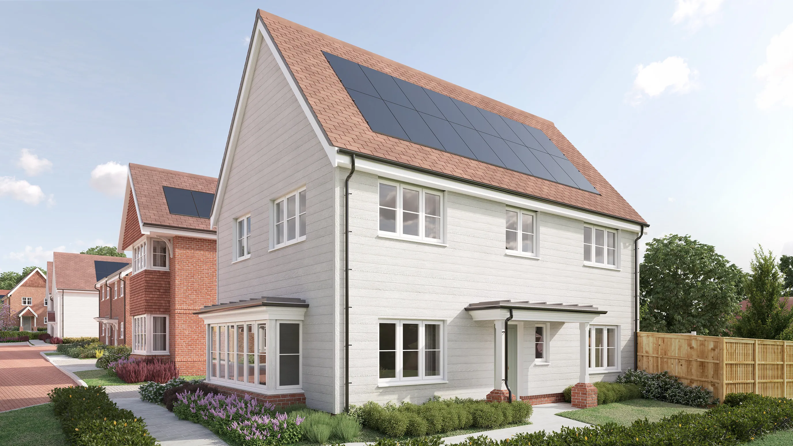 CGI of a modern detached house with a pitched roof fitted with solar panels, combining eco-conscious design and suburban comfort. The light-colored exterior features white horizontal siding, large windows, and a small covered porch. In front, a landscaped garden with flowering shrubs and neatly trimmed hedges adds vibrancy. A similar house is visible behind, hinting at a cohesive neighborhood layout.