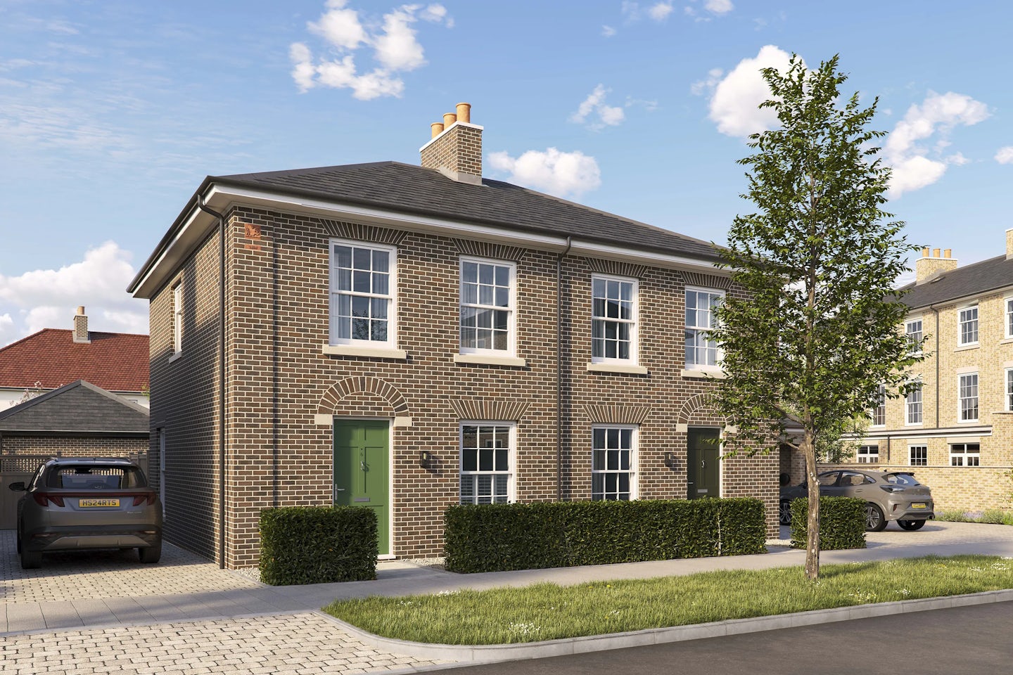 Modern semi-detached brick house with two green front doors and white-framed sash windows. Each entrance is framed by an arched brick detail above the door. A low hedge runs along the front of the property, and a tree is planted on the pavement in front. A car is parked on a driveway to the left, and additional similar houses are visible in the background under a bright blue sky with scattered clouds.