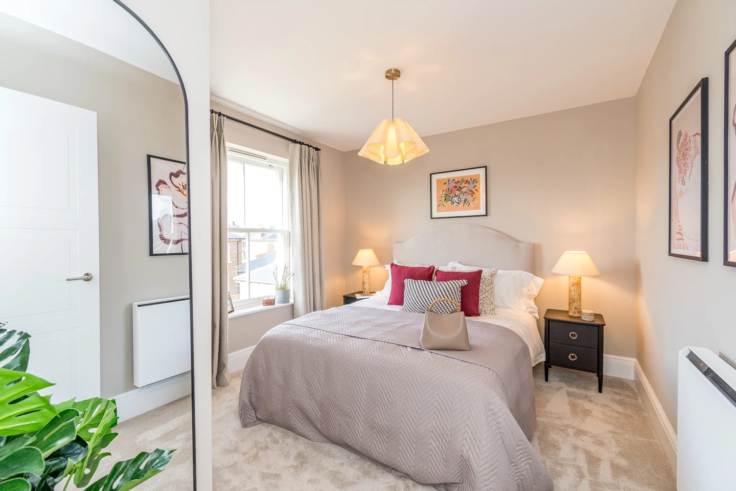 A double bedroom with a neatly made bed, bedside tables with lamps, neutral décor, and a window letting in natural light.