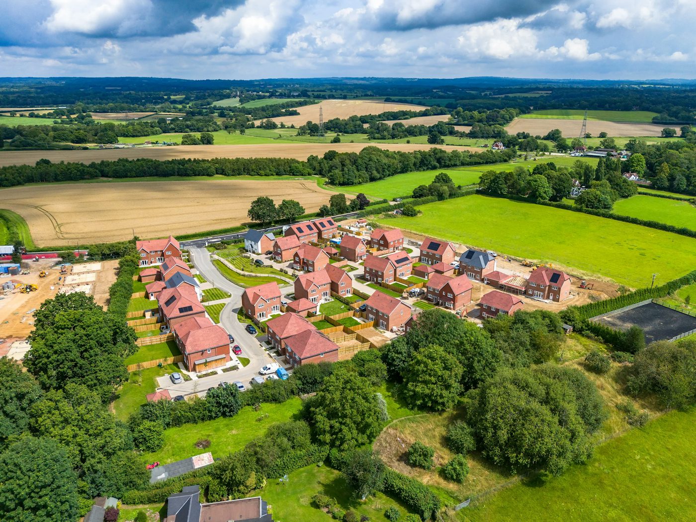 Aerial view of a new housing development surrounded by green fields and countryside.