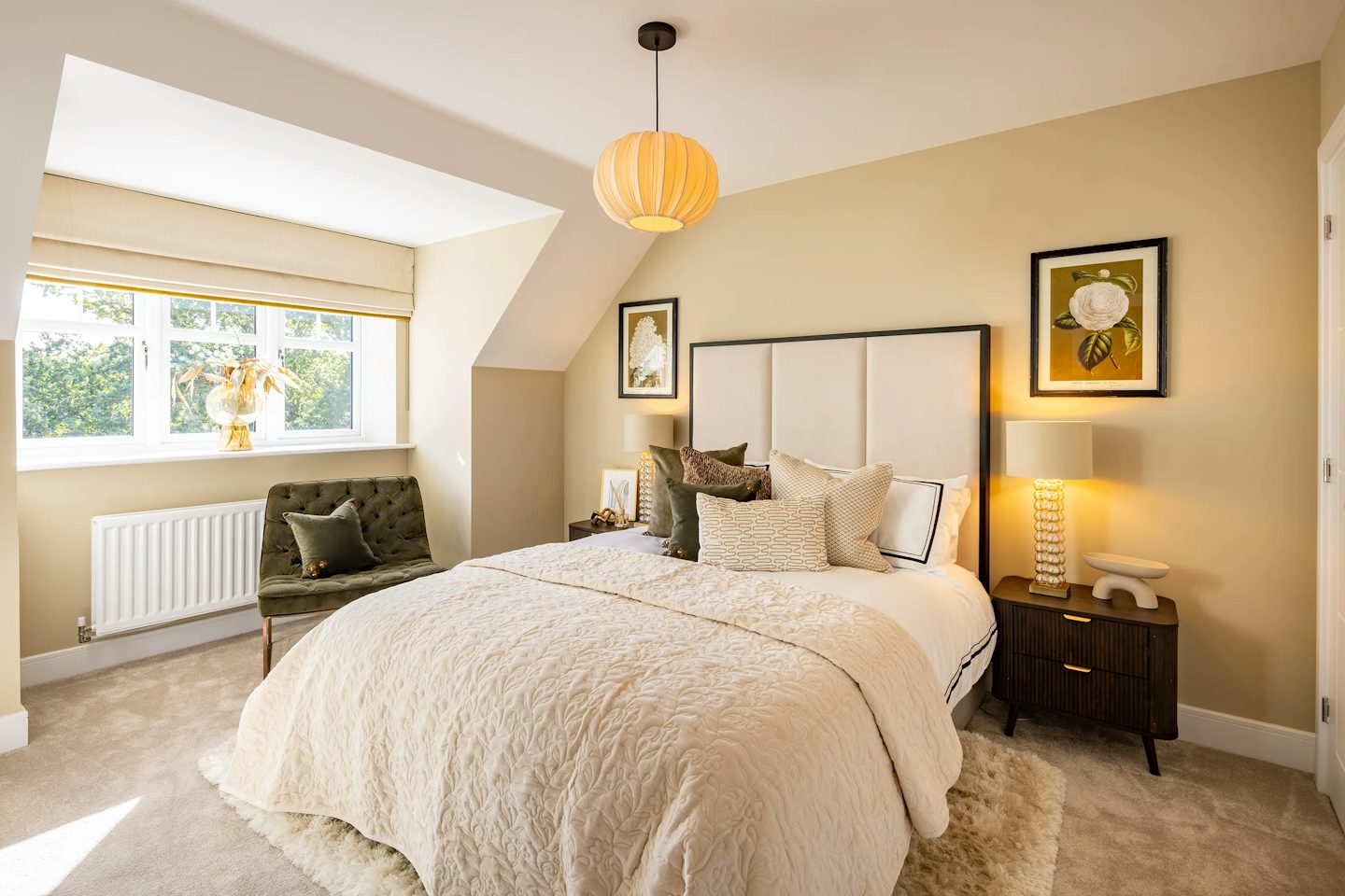 Elegant main bedroom with a padded headboard, bedside tables and lamps, feature artwork, and a large window.