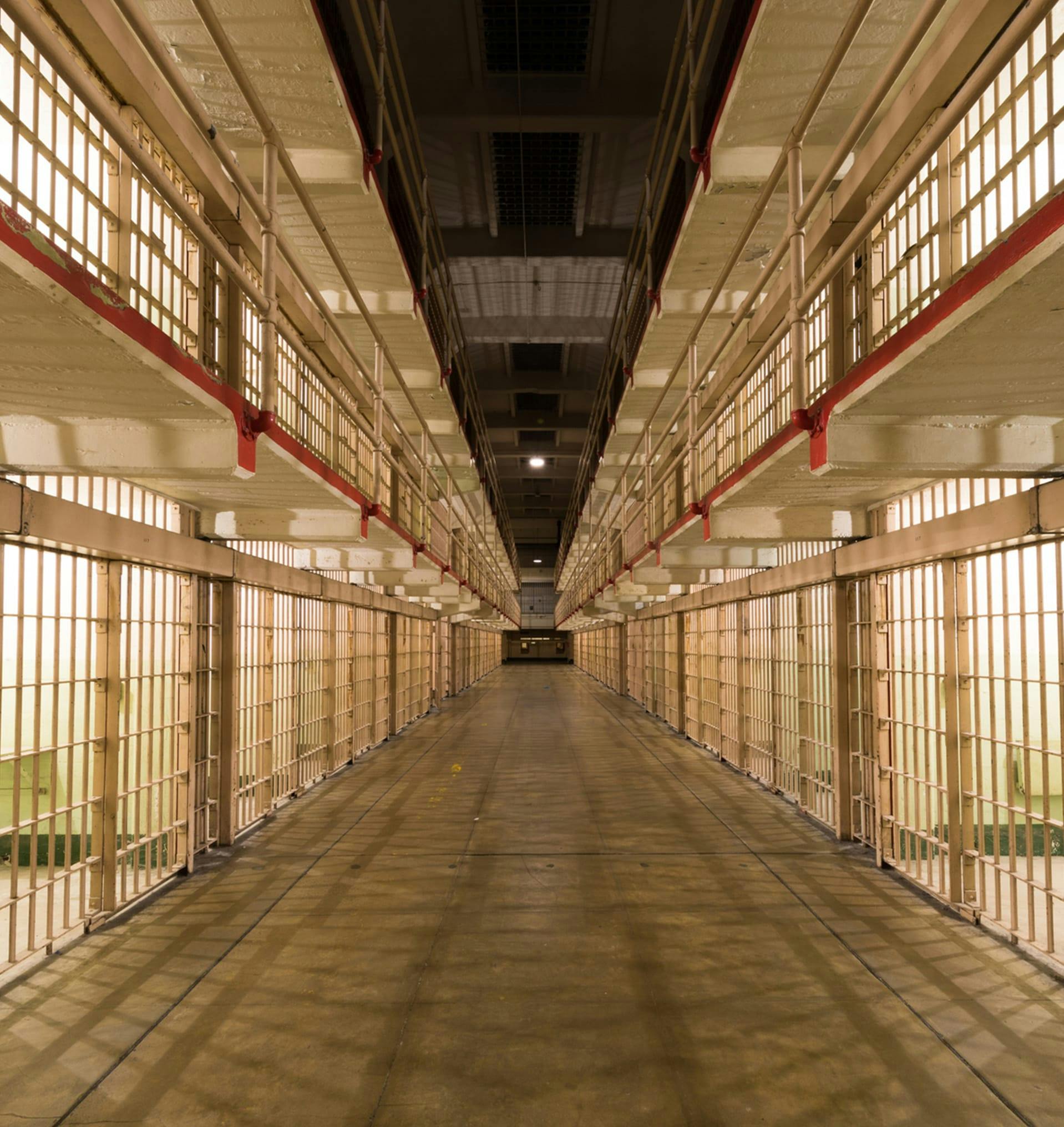 View of a jail with cells to left and right.