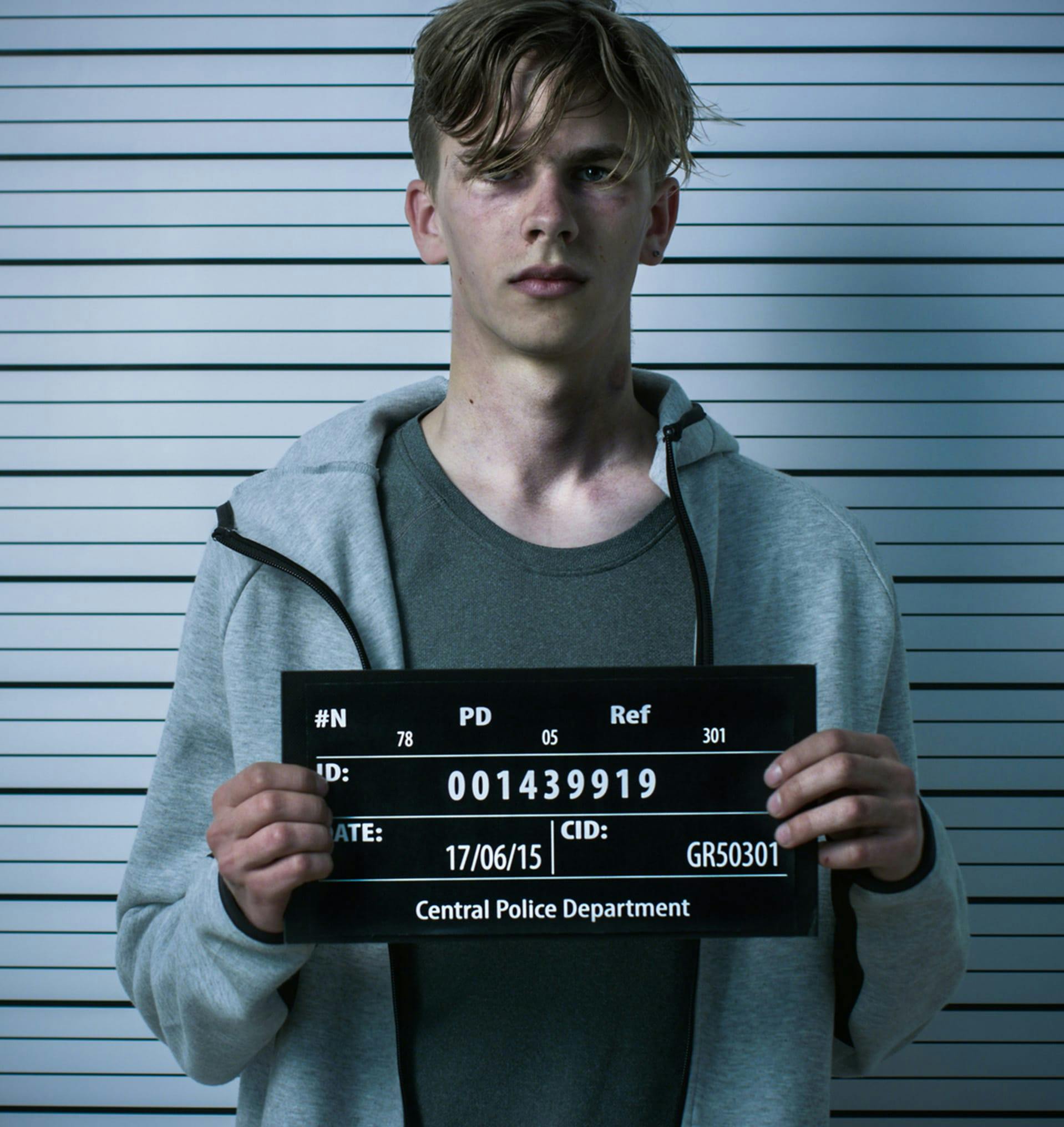 Man standing getting a photo taken at the police department.