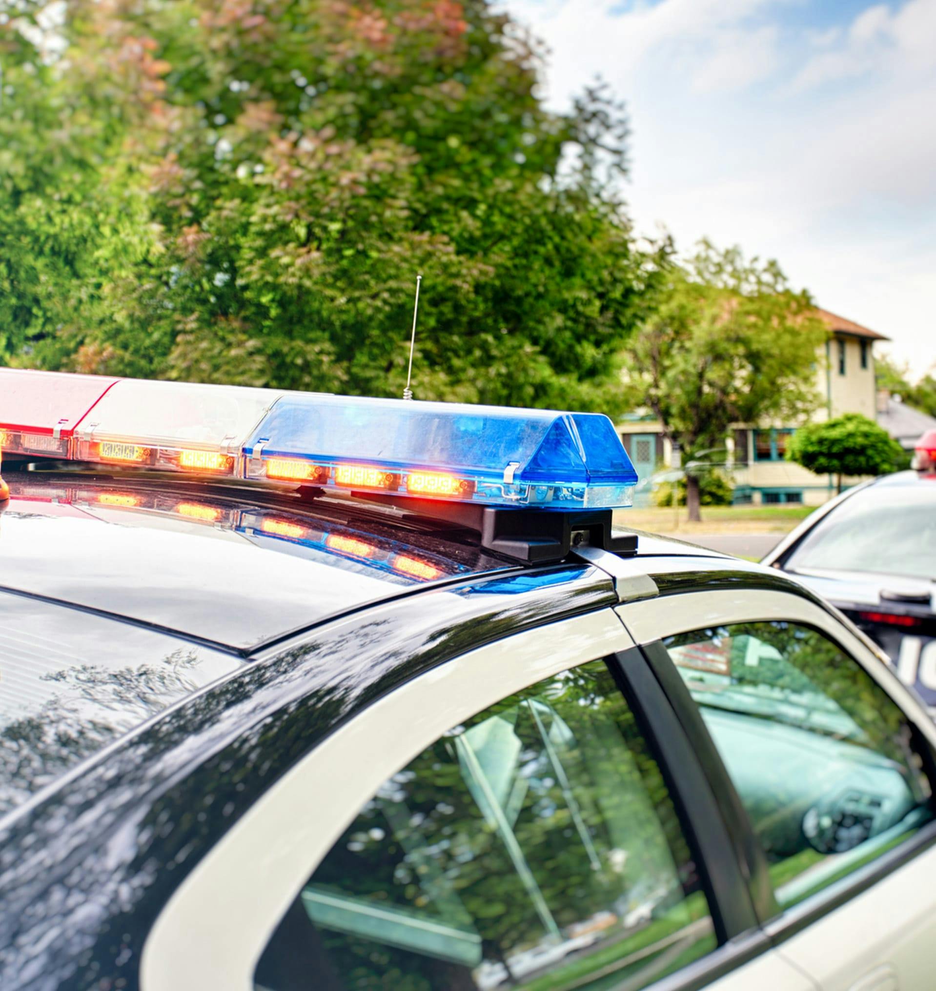 Police car outside of a neighborhood.