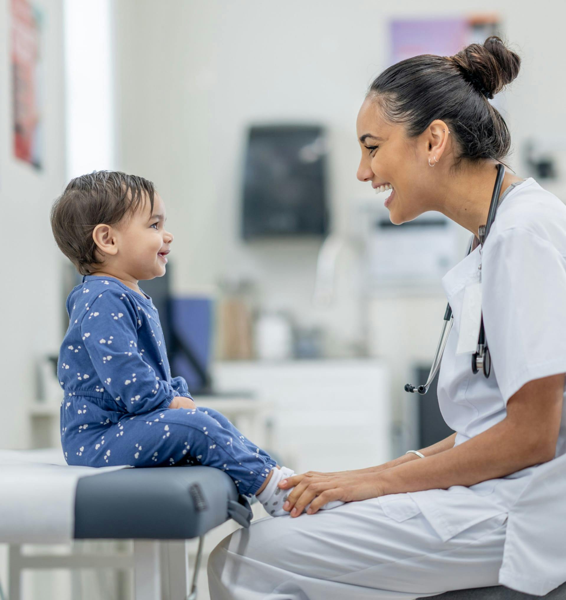 Nurse smiling and helping a happy child.