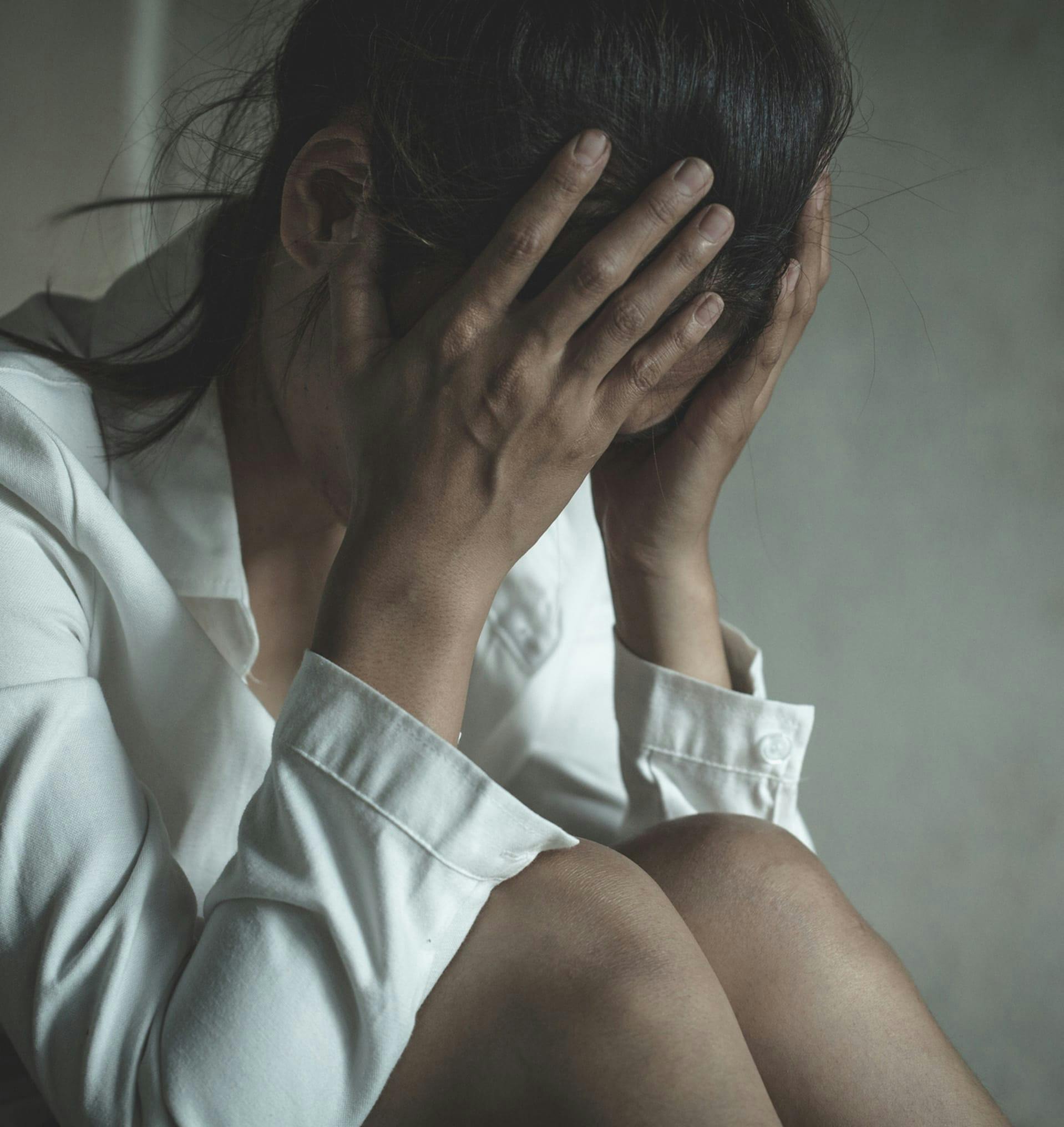 Distressed woman holding her head.