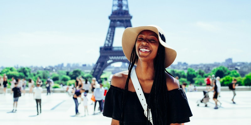 woman standing behind Eiffel Tower during daytime