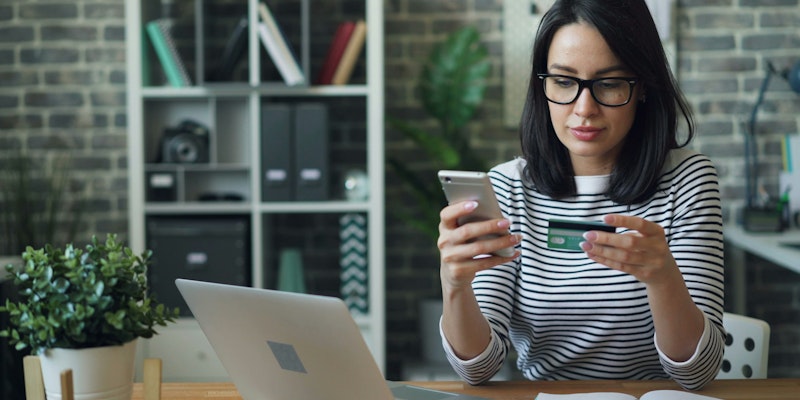 a woman sitting at a table looking at her cell phone