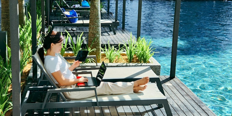 a person sitting on a bench with a laptop