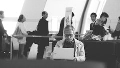 a man sitting at a table using a laptop computer