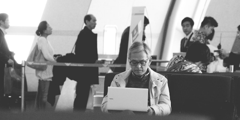 a man sitting at a table using a laptop computer