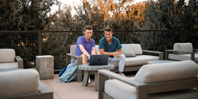 man in blue polo shirt sitting on white couch