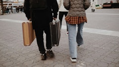 a man and a woman walking down a street with luggage