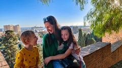 a woman and two children sitting on a bench