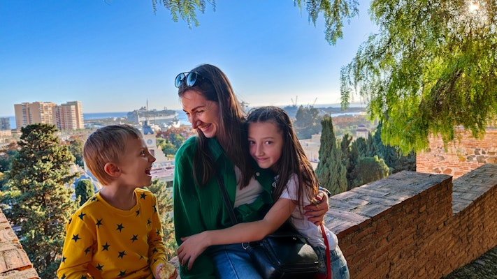 a woman and two children sitting on a bench