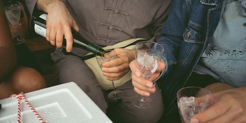 a group of people sitting around drinking wine