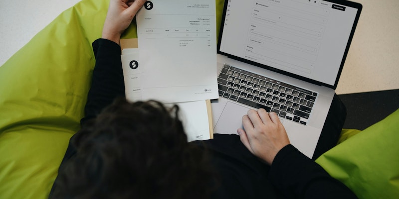 A person sitting on a bean bag chair working on a laptop