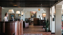 A woman is standing at the front desk of a restaurant