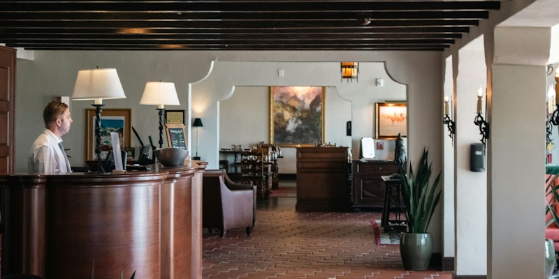 A woman is standing at the front desk of a restaurant