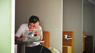 man wearing white top using MacBook