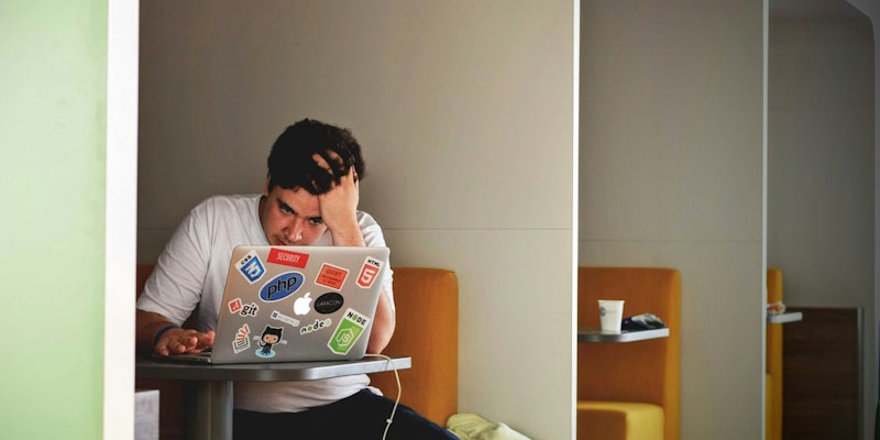 man wearing white top using MacBook