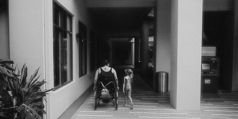 A man pushing a stroller down a hallway