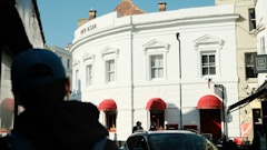 Person walking down the street in Europe and looking at a white hotel