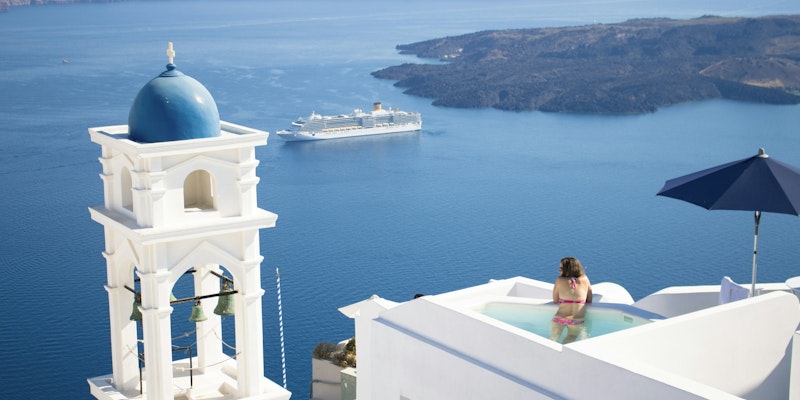 Person staring out at the bay in a hotel pool in Greece