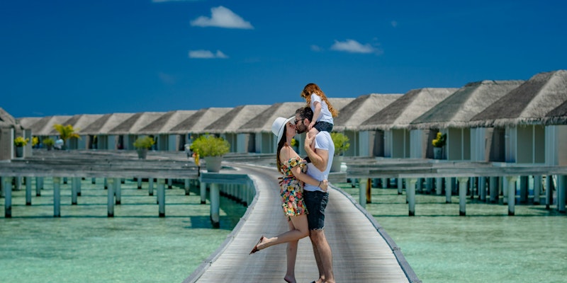 woman in white tank top and black shorts standing on wooden dock during daytime