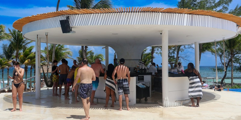 A group of people standing around a swimming pool