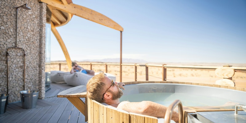 a man relaxing in a hot tub on a deck