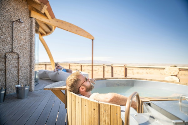 a man relaxing in a hot tub on a deck