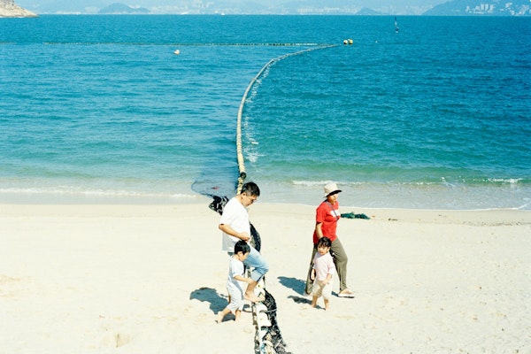 Family walking on a sandy beach by the ocean