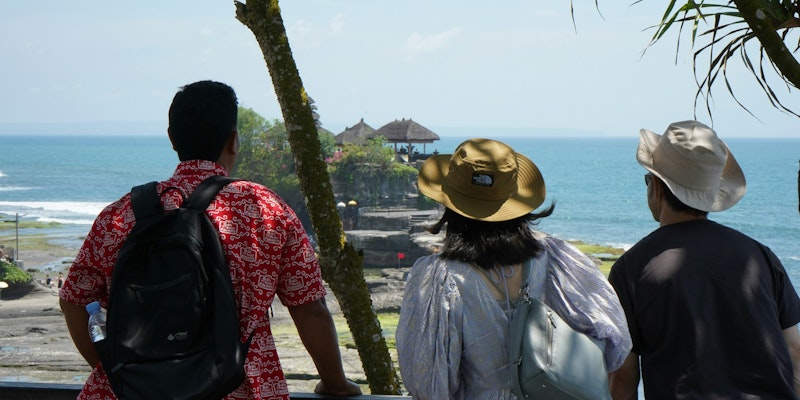 two men and a woman looking out at the ocean