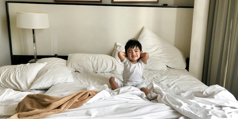 woman in white long sleeve shirt lying on bed