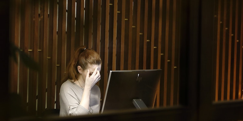 a woman sitting in front of a laptop computer