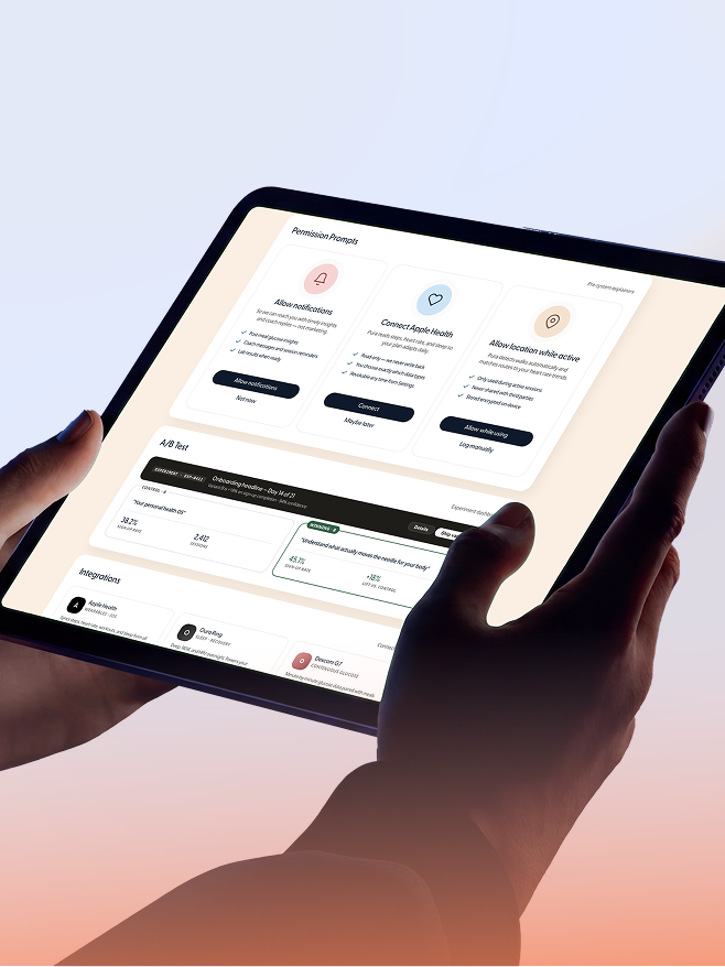 Hands holding a tablet reviewing an AI-generated page of permission prompts, an A/B test panel, and device integrations, the designer review pass the output still needs.