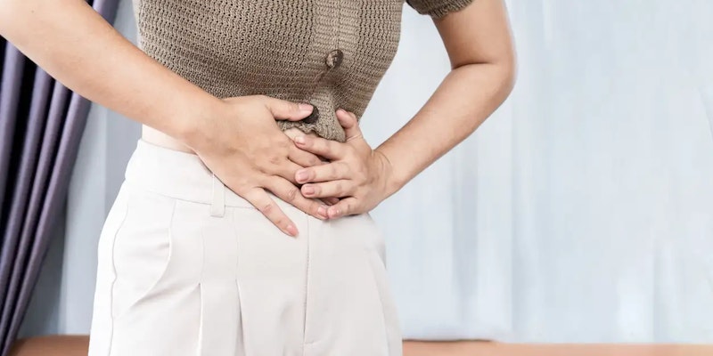 Imagem de pessoa com as mãos na barriga, indicando que está com dores, um dos sintomas que o xantinon é indicado.