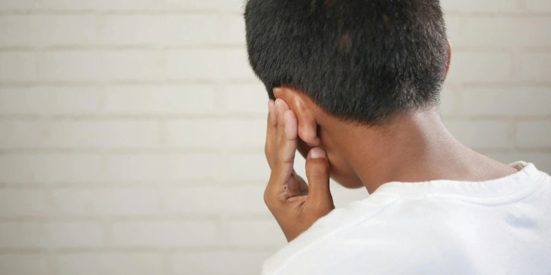 Imagem de um menino com dores de ouvido, indicando necessidade de uso de Otosylase.