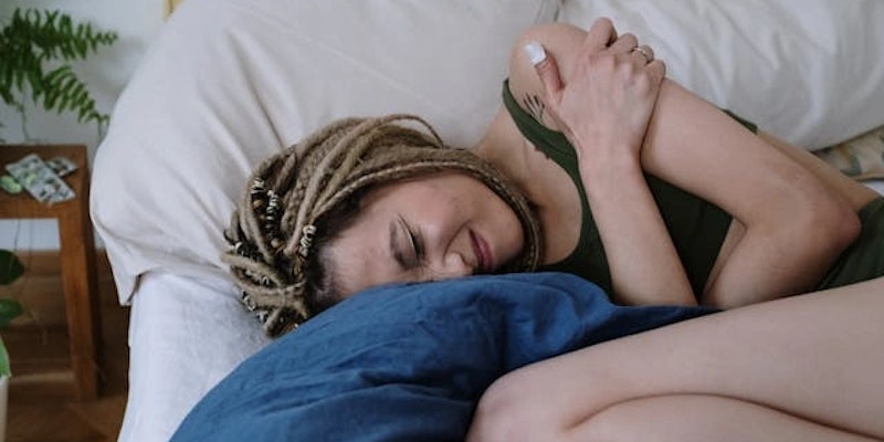 Imagem de mulher com cólicas.