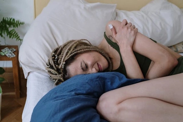 Imagem de mulher com dor abdominal por infecção bacteriana, indicando uso de Metronizazol.
