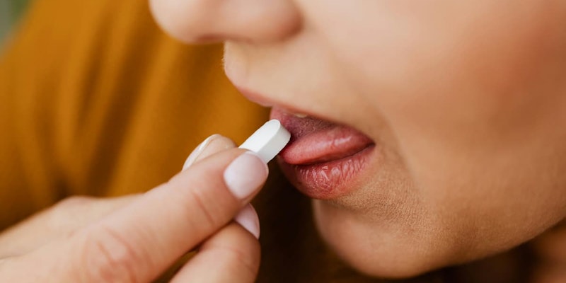 Pessoa colocando comprimido na boca para ilustrar o uso de Zirvit Multi Max como suplemento vitamínico e mineral.