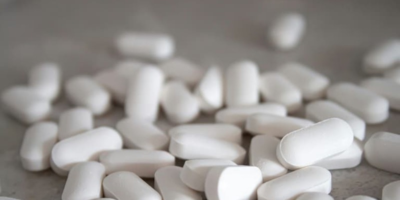 Comprimidos de paracetamol espalhados sobre uma superfície para aliviar dores e reduzir a febre.