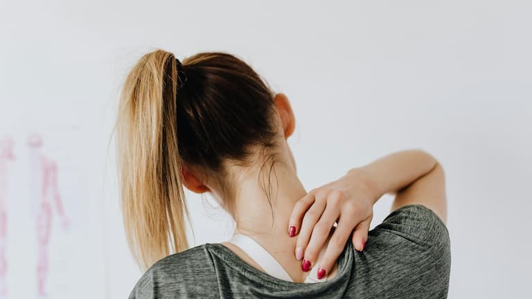 Pessoa com a m&atilde;o sobre a regi&atilde;o do ombro e pesco&ccedil;o com dor muscular e desconforto neurop&aacute;tico, condi&ccedil;&otilde;es frequentemente associadas ao uso de gabapentina.