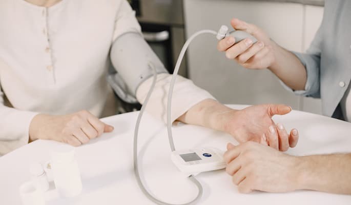 para-que-serve-selozok Profissional de saúde realizando a aferição da pressão arterial de uma paciente com aparelho digital