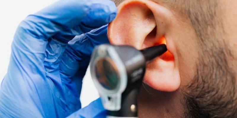 Profissional de saúde examinando o ouvido de um paciente com um otoscópio com diagnóstico e tratamento de infecções e inflamações do ouvido para o uso de Otociriax.