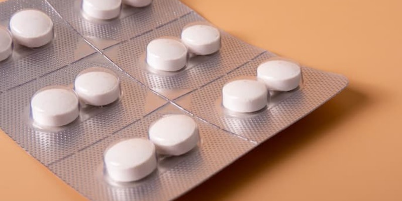 Comprimidos de azitromicina em cartelas sobre uma superfície laranja.