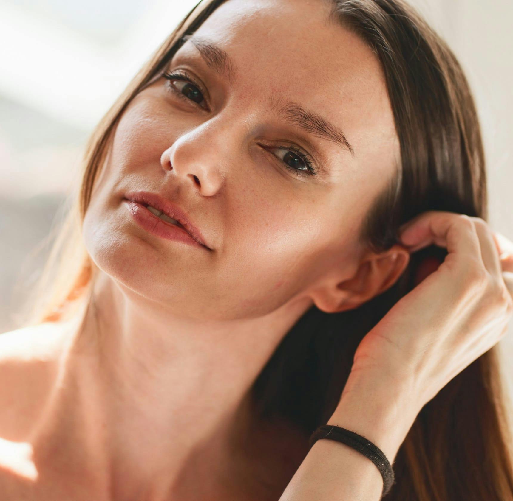 woman moving her hair and tucking it behind her ear
