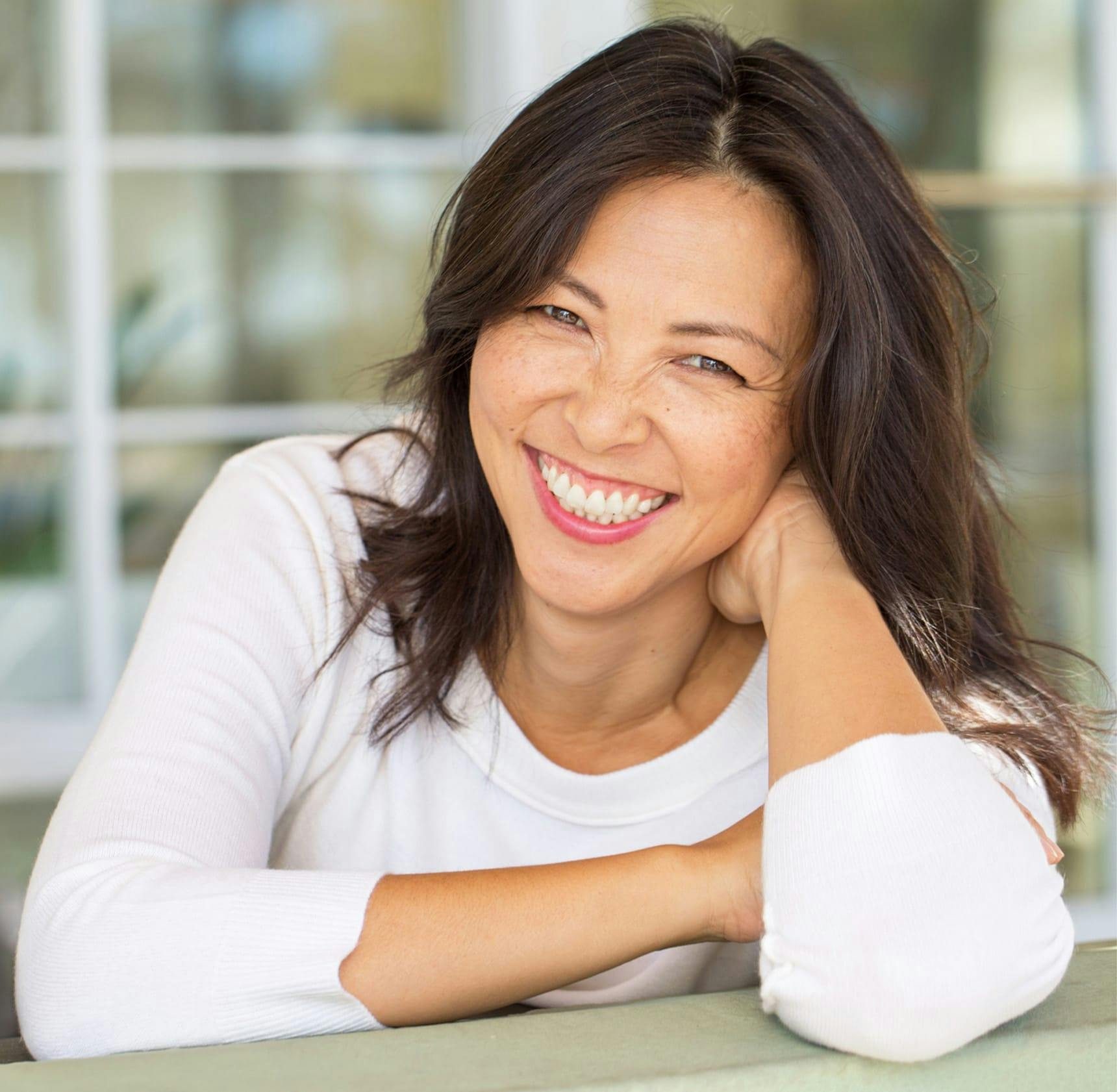 woman leaning on table smiling